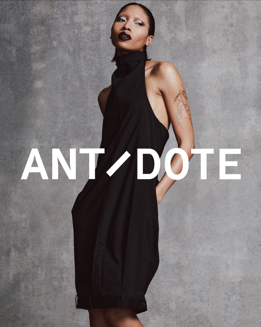 SS25 women’s editorial featuring model in asymmetric Hodakova tube dress and metallic Amina Muaddi boots — a statement look styled with dark minimalist energy. Shop Hodakova now at our Atlanta luxury boutique.