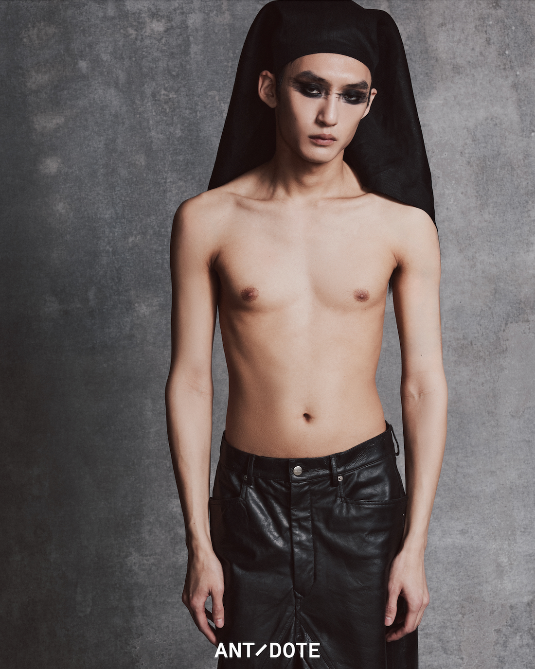 Avant-garde SS25 editorial image of Brandon in all-black Rick Owens look with blunt wig, asymmetric leather skirt, and platform boots. Explore and shop our selection of Rick Owens pieces now at our Atlanta luxury boutique.